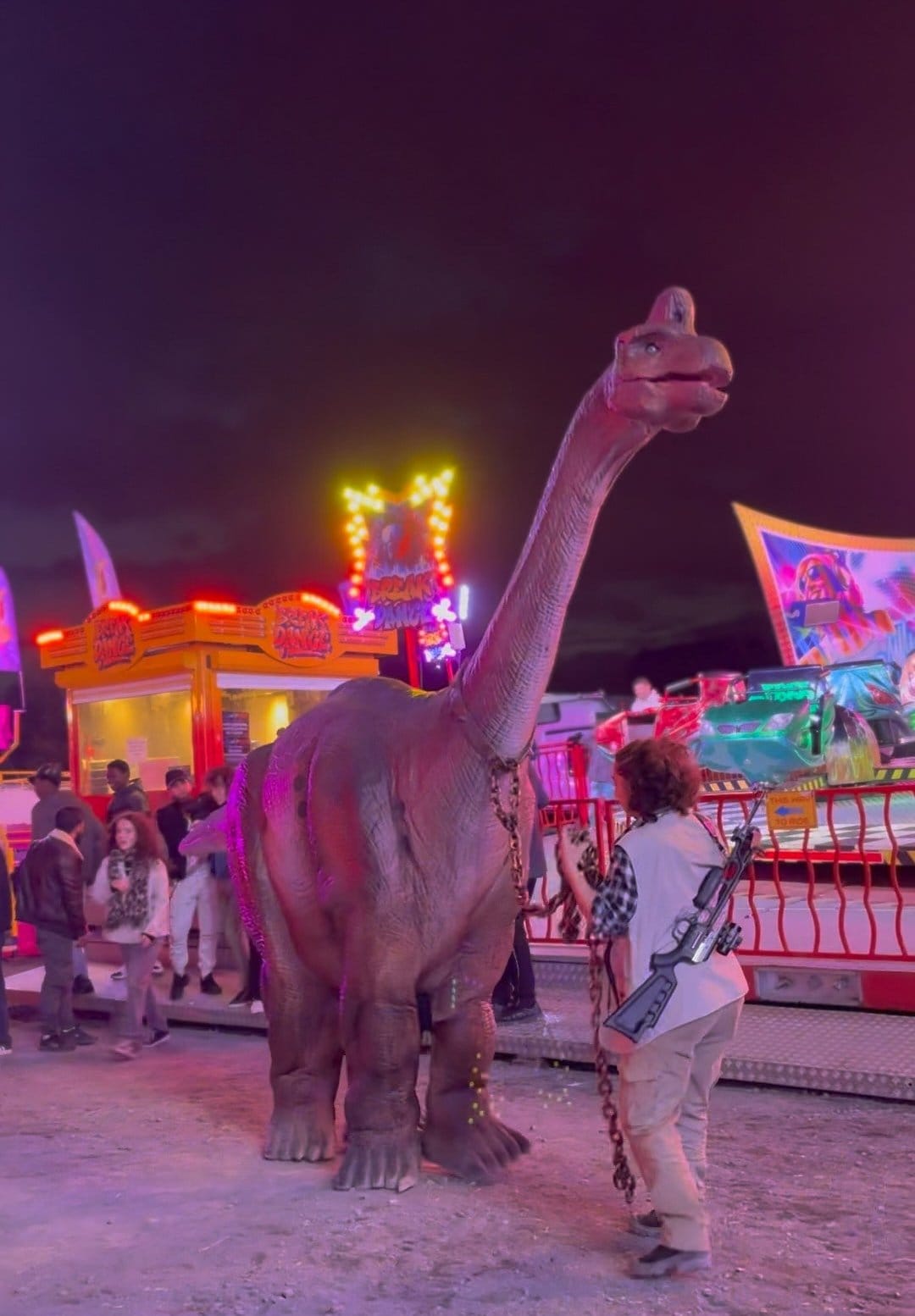 Le diplodocus animé de Mascotte Dreams, un soir de fête foraine