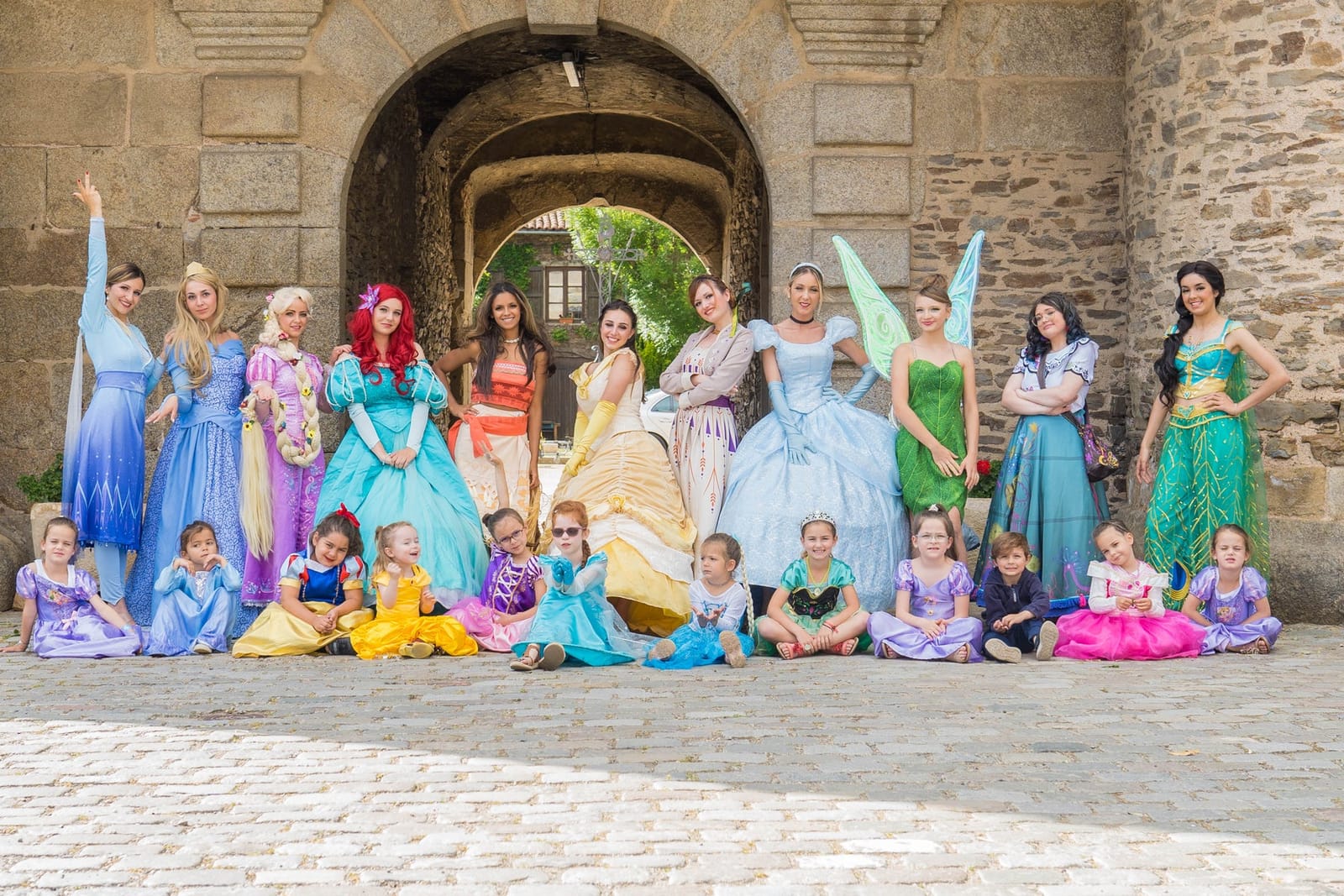 Les princesses de Mascotte Dreams avec des enfants déguisés, sous une porte de château